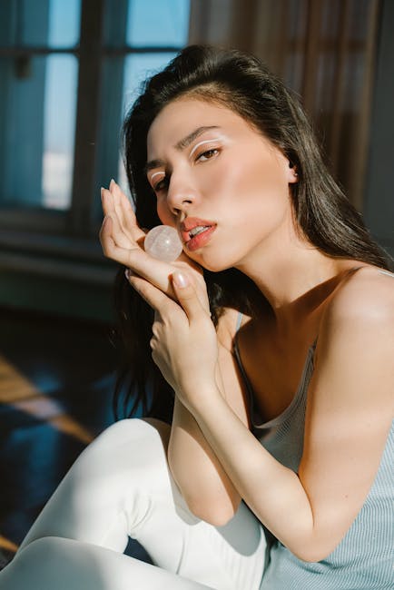 Woman sitting in a graceful lotus yoga pose in a sunlit room